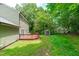 Well-maintained backyard showcasing a wooden deck, storage shed, and a spacious grassy area at 3330 Nantuckett Ave, Durham, NC 27703