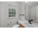 Bright bathroom with white fixtures, vanity and a large window bringing in natural light at 3330 Nantuckett Ave, Durham, NC 27703