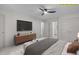 Staged bedroom with TV and neutral decor featuring a ceiling fan and closet doors at 3330 Nantuckett Ave, Durham, NC 27703