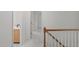Bright hallway with neutral carpet, wooden banister, and access to a vanity with sink at 3330 Nantuckett Ave, Durham, NC 27703