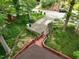Aerial view of the property featuring a long driveway and stairs leading up to the wooden deck surrounding the home at 3416 Ocotea St, Raleigh, NC 27607