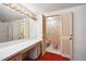 A pink vintage tiled bathroom with large mirror, vanity, and separate toilet area at 3416 Ocotea St, Raleigh, NC 27607