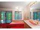 The Primary bathroom features a pink sunken tub with gold fixtures and floor to ceiling windows at 3416 Ocotea St, Raleigh, NC 27607