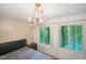 Bedroom with a large bed, a chandelier and a window with a view of the woods at 3416 Ocotea St, Raleigh, NC 27607