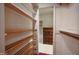 Walk-in closet with wooden shelving and a view into a room with a dresser at 3416 Ocotea St, Raleigh, NC 27607