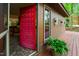 Exterior view of a brown two-story house with a bright red front door and wrap around deck at 3416 Ocotea St, Raleigh, NC 27607