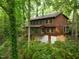Backside exterior elevation featuring a screened-in porch, lower basement access, and lush foliage surrounding the property at 3416 Ocotea St, Raleigh, NC 27607