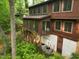 Backside exterior elevation featuring a screened-in porch, lower basement access, and lush foliage surrounding the property at 3416 Ocotea St, Raleigh, NC 27607