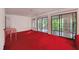 Spacious living room featuring red carpet, white walls, and sliding doors to the outside at 3416 Ocotea St, Raleigh, NC 27607