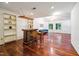 Living room featuring hardwood floors, a blue couch, a bar and large windows overlooking an outdoor space at 3416 Ocotea St, Raleigh, NC 27607