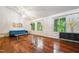 Living room featuring hardwood floors, a blue couch, and large windows overlooking a green outdoor space at 3416 Ocotea St, Raleigh, NC 27607