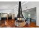 Living room featuring hardwood floors, a brick fireplace, chandelier, and large windows overlooking a green outdoor space at 3416 Ocotea St, Raleigh, NC 27607