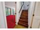 Wood staircase leading from the red living room to the upper floors at 3416 Ocotea St, Raleigh, NC 27607