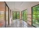Bright sunroom featuring a marble floor, wood trim and large windows with scenic wooded views at 3416 Ocotea St, Raleigh, NC 27607