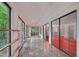 Long sunroom with marble floors and glass sliding doors leading to a red living room at 3416 Ocotea St, Raleigh, NC 27607
