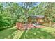 Inviting back deck, with built in benches, surrounding a mature shade tree for backyard relaxation and outdoor living at 36 Birnamwood Dr, Chapel Hill, NC 27516