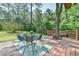 Back deck featuring an outdoor table and chairs on a green outdoor rug, surrounded by a lush green backyard at 36 Birnamwood Dr, Chapel Hill, NC 27516