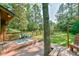 Private back deck with seating area, overlooks large backyard with green grass and mature trees at 36 Birnamwood Dr, Chapel Hill, NC 27516