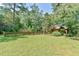 Sprawling, verdant backyard featuring a wood fence, mature trees, and landscaping at 36 Birnamwood Dr, Chapel Hill, NC 27516