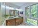 Bathroom featuring double sinks, wooden mirror, and a large window with a view at 36 Birnamwood Dr, Chapel Hill, NC 27516