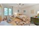 Cozy bedroom featuring a ceiling fan, large windows, and a comfortable chair and bed at 36 Birnamwood Dr, Chapel Hill, NC 27516