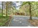 Gravel driveway leading to a wood-sided single-Gathering home surrounded by lush green trees at 36 Birnamwood Dr, Chapel Hill, NC 27516