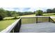 Back deck overlooking a lush lawn, mature trees, and a white picket fence providing privacy at 3684 Ben Mil Ct, Franklinton, NC 27525