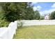 Lush backyard with mature trees and a white picket fence, offering a picturesque view and ample privacy at 3684 Ben Mil Ct, Franklinton, NC 27525
