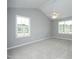 Bright bedroom with neutral carpet, vaulted ceiling, and natural light from the windows at 3684 Ben Mil Ct, Franklinton, NC 27525