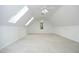 Large, bright bonus room with vaulted ceilings, skylights, carpet flooring, and two ceiling fans at 3684 Ben Mil Ct, Franklinton, NC 27525
