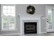Close-up of the fireplace with marble mantel, wreath, and windows with shutters to the side at 3684 Ben Mil Ct, Franklinton, NC 27525