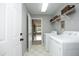 Bright laundry room with washer, dryer, overhead shelving and view into dining room at 3684 Ben Mil Ct, Franklinton, NC 27525