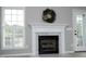 Bright living room showcases a fireplace with a decorative wreath and large windows with white shutters at 3684 Ben Mil Ct, Franklinton, NC 27525