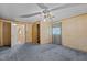 Bedroom with paneled walls, carpet, closet, and a window with curtains at 4038 Redwood Rd, Durham, NC 27704