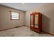 Simple bedroom featuring carpet flooring, a window for natural light, and a classic wardrobe at 4038 Redwood Rd, Durham, NC 27704