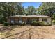 Charming single-story brick home featuring green shutters and a well-maintained front yard at 4038 Redwood Rd, Durham, NC 27704