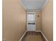 Hallway with paneled walls, white door, and vinyl flooring at 4038 Redwood Rd, Durham, NC 27704