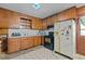 Well-lit kitchen featuring wood cabinets, a vintage stove, and a classic tile floor at 4038 Redwood Rd, Durham, NC 27704