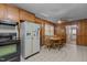 Open kitchen with wood paneling, a vintage refrigerator, and a cozy dining space at 4038 Redwood Rd, Durham, NC 27704