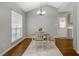 Bright dining area with a modern light fixture, hardwood floors, and a view of the backyard at 4524 Sugar Maple Rd, Oxford, NC 27565