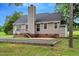 Rear exterior showing well-kept lawn, patio, siding, chimney, and brick foundation at 4524 Sugar Maple Rd, Oxford, NC 27565