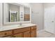 Bathroom with a large mirror and a wooden vanity and view to the yard at 4724 Ludwell Branch Ct, Raleigh, NC 27612