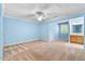 A bedroom with a vanity, carpeted floors, a ceiling fan, and light-blue walls at 4724 Ludwell Branch Ct, Raleigh, NC 27612