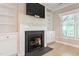 Cozy living room features a black fireplace, white built-in shelving, and tile flooring at 4724 Ludwell Branch Ct, Raleigh, NC 27612