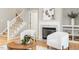 Cozy living room featuring a white fireplace, staircase, and lots of natural light at 4724 Ludwell Branch Ct, Raleigh, NC 27612