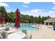 Community pool featuring ample seating, large umbrellas, and a well maintained pool deck with a nearby restroom at 4724 Ludwell Branch Ct, Raleigh, NC 27612