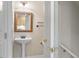 Classic powder room featuring a pedestal sink, decorative mirror, and neutral tones at 4724 Ludwell Branch Ct, Raleigh, NC 27612