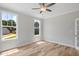 Bright bedroom with light wood floors, two windows, a ceiling fan, and fresh, neutral paint at 4896 Grosbeak Ct, Mebane, NC 27302