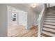 Bright entryway with light wood floors, white trim, a staircase, and an open doorway to another room at 4896 Grosbeak Ct, Mebane, NC 27302
