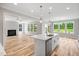 Bright, open kitchen featuring white cabinets, stainless steel appliances, and an island with a sink and quartz countertop at 4896 Grosbeak Ct, Mebane, NC 27302
